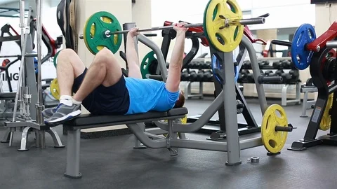 A man raises the bar lying on the bench Stock Footage 102249403