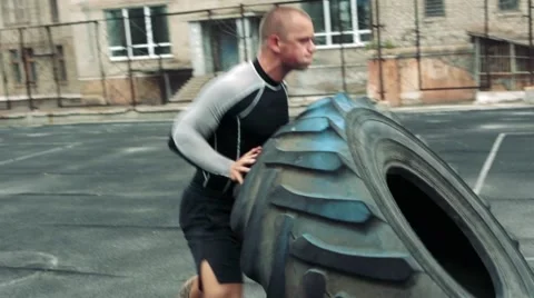 Man raises a big tire Stock Footage 67289832