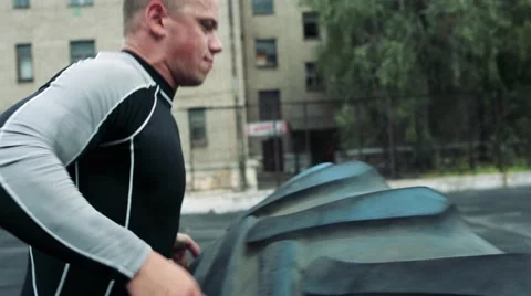 Man raises a big tire Stock Footage 67289894