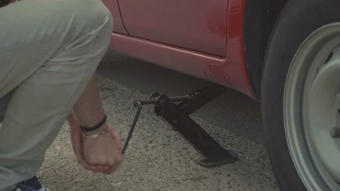 Man Raises A Car Using A Jack Video stock 127958708