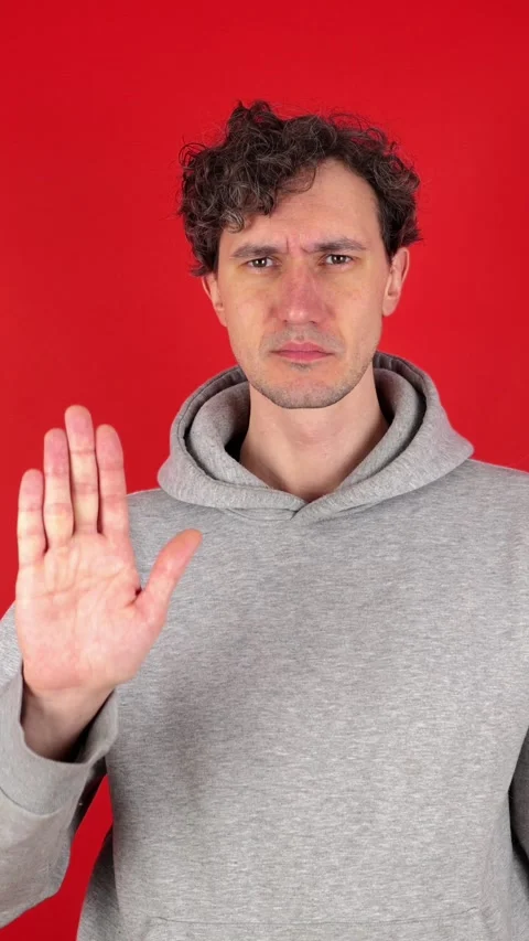 Man raises hand, palm forward, showing in front sign stop, ban, rejected gesture 動画素材 304761638