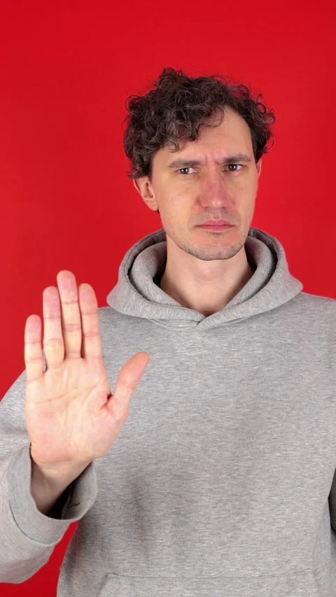 Man raises hand, palm forward, showing in front sign stop, ban Stock Footage 304761661