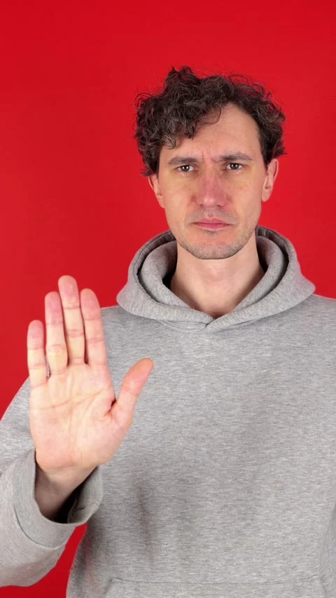 Man raises hand, palm forward, showing in front sign stop, ban, rejected gesture 動画素材 304761675