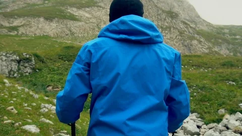 Man raises hands up standing back on mountain top morning. No face male Stock-Footage 99428146
