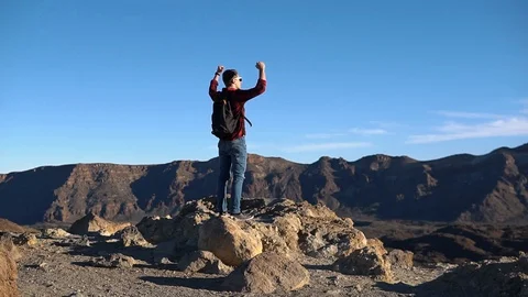 Man raises hands up standing back on mountain top morning sun shine slow motion Stock-Footage 105231623