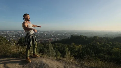 Man raises hands up standing back on mountain top morning sun shine slow motion Stock Footage 126496332