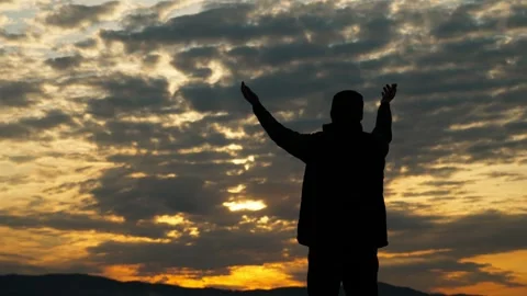 The man raises his hands to the sky, asking for God&amp;#039;s blessing. Vídeo Stock 337565520