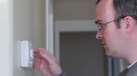 A man raises the temperature on thermostat in a cold house Video stock 46571784