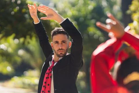 Man raising the arms while dancing flamenco with a woman in flamenco dress Stock Photos