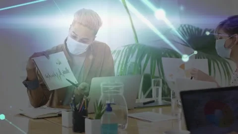 Man raising chart and pointing trends at desk, animated overlay moving across Stock Footage 333802985