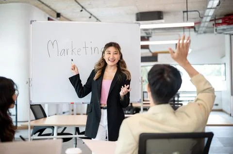 Man raising hand asking question to businesswoman after explaining marketin.. Stock Photos