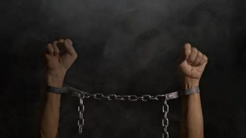 A man raising his arms bound in chains Stock Footage 320499391
