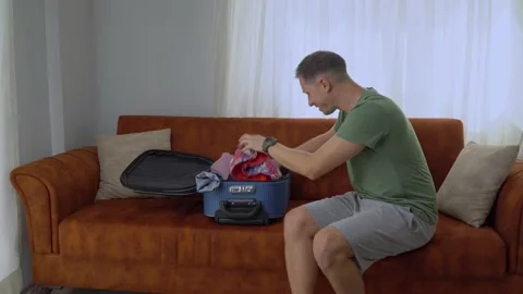 A man randomly throws things into a suitcase, rushes on a trip, does not have Stock Footage 204985887