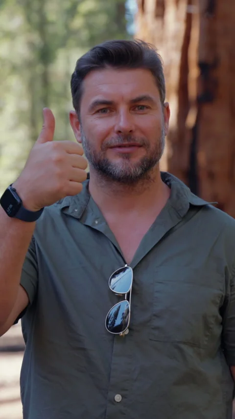 Man ranger pointing thumbs up standing in the woods among the trees Stock Footage 295165826