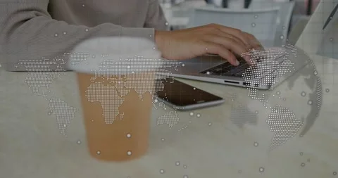 Man reaching cup, withdrawing, typing on laptop for tech work, phone idling, map Stock Footage 330576916