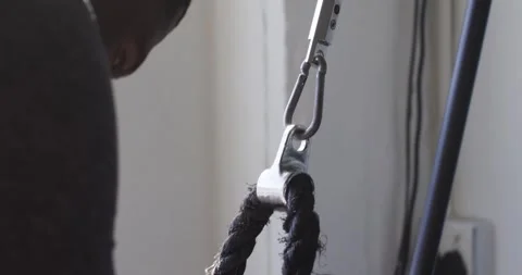 Man reaching, grasping braided rope handles and pulling for gym workout, copy Stock Footage 340751054