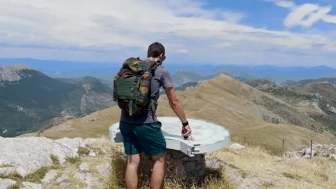 Man Reaching Mountain Summit Standing at Orientation Table Stock Footage 338007287