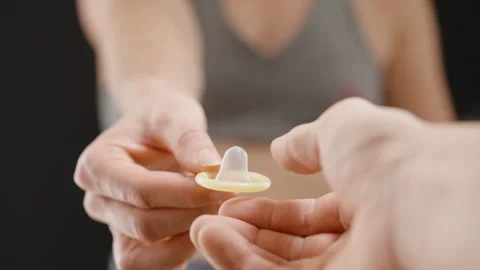 A Man Reaching Out to Take a Condom from a Woman, Depicting Shared Stock Footage 300901642