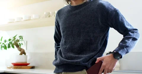 Man reaching right pocket, pulling red phone, checking texts at kitchen counter Stock Footage 341079701