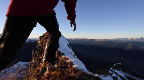 A man reaching the summit after climbing on a snow covered mountain. Stock Footage
