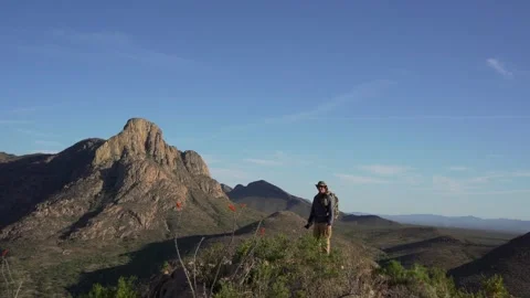 A man reaching the summit of a scenic mountain top Stock Footage 274727401