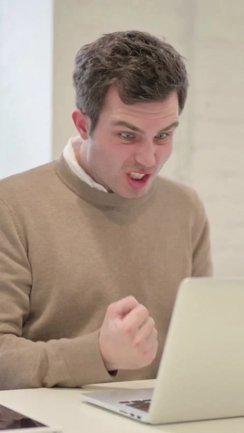Man Reacting to Loss While using Laptop, Vertical Video 動画素材 337351158