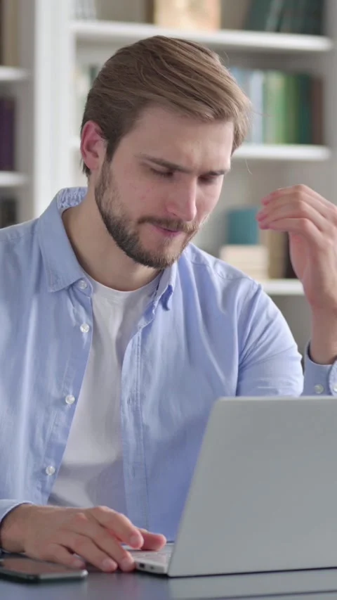 Man Reacting to Loss While using Laptop, Vertical Video Stock Footage 339577769