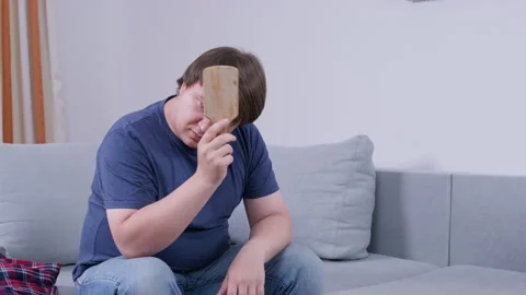 Man reacting to unexpected message while alone on sofa in casual home setting Stock Footage 316008602