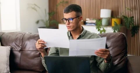 Man, reading and documents with laptop in home for finanial planning, audit.. Stock Photos