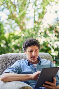 Man, reading and scroll in backyard with tablet, website and browse digital.. Stock-Fotos