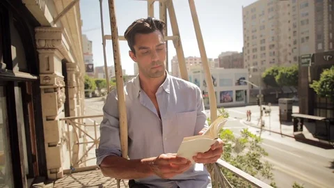 Man reading on balcony 01 스톡 동영상 76734958