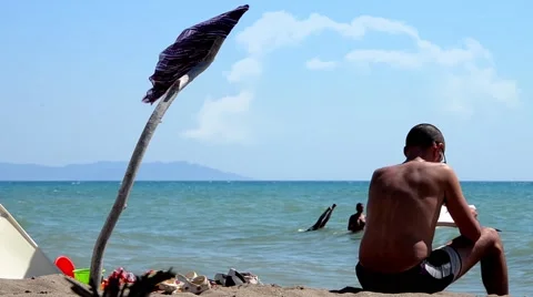 Man reading on the beach Stock Footage 44445784