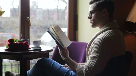 Man reading book and drinking coffee in the restaurant Vídeos de archivo 48753191