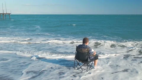 Man reading book on the beach Stock Footage 168298256