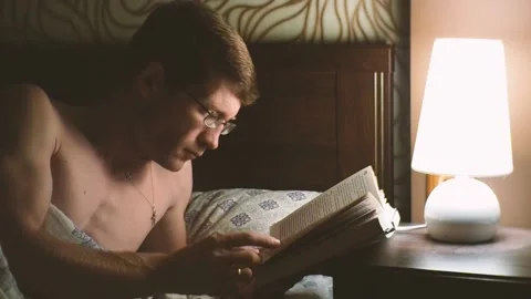 Man reading book in bed. Stock Footage 96984156