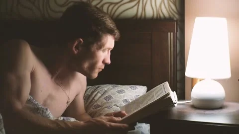 Man reading book in bed. Stock Footage 96985146