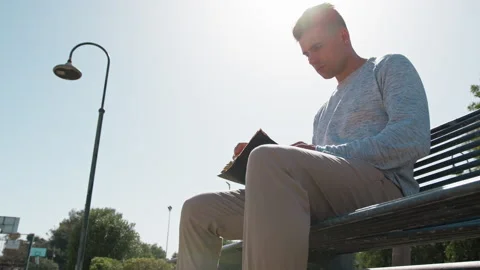 Man Reading A Book On A Bright Sunny Day Stock Footage 277167008