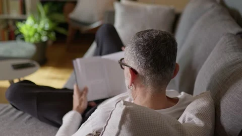 Man reading book on couch. Stock Footage 220417457