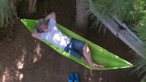 Man reading book on a hammock. 4K Stock Footage 195661226