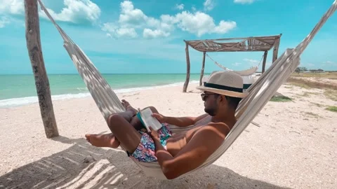 Man reading a book in hammock on the beach, La Guajira, Colombia Stock Footage 266592495