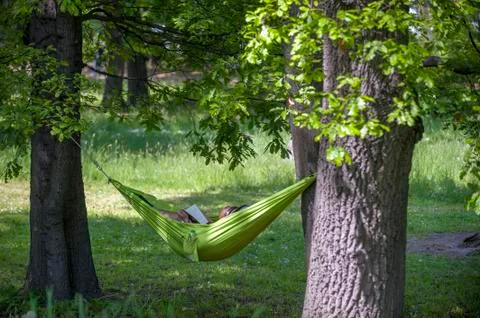 Man reading a book in a hammock. Stock Photos