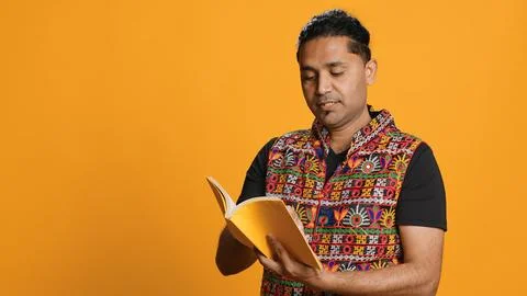 Man reading book, having fun, isolated over studio background Fotos de archivo
