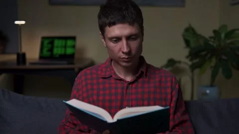 Man reading a book instead of using laptop, symbol of digital detox and mindful Video stock 318478830
