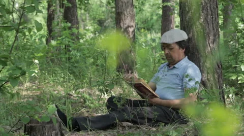 Man reading a book on nature. Stock Footage 63836429