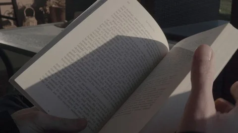 Man reading a book outside, turning the page, hd Stock Footage 124279465