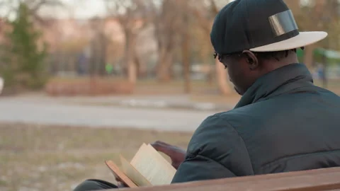 Man Reading Book On Park Bench Outdoors Vídeos de archivo 318718209
