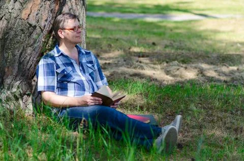 Man is reading book in pine forest Foto stock