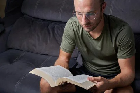 Man reading a book relaxed on the sofa Stock Photos