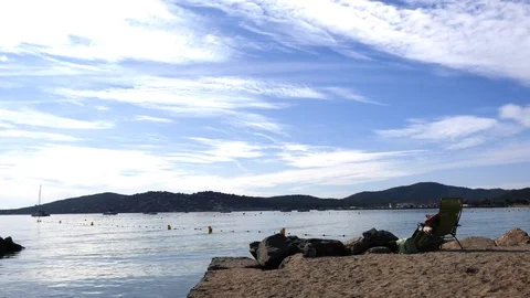 Man reading a book by the sea Stock Footage 80023267
