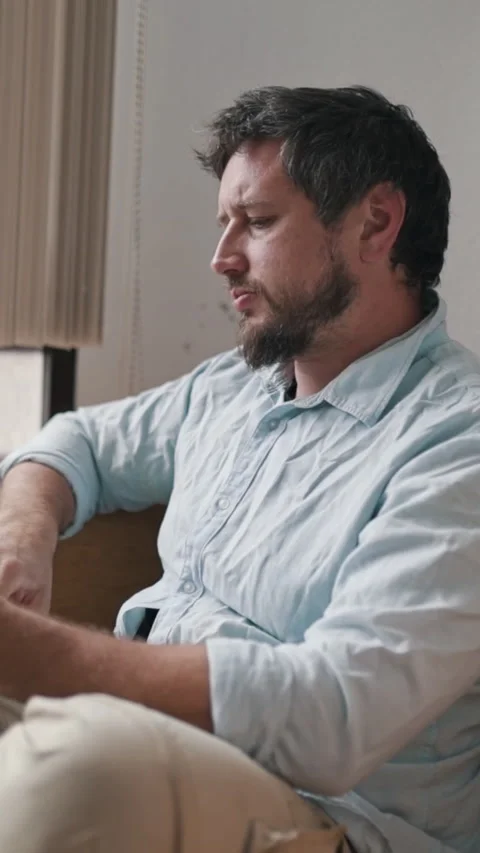 Man reading a book on sofa and feeling bored Stock Footage 327445768